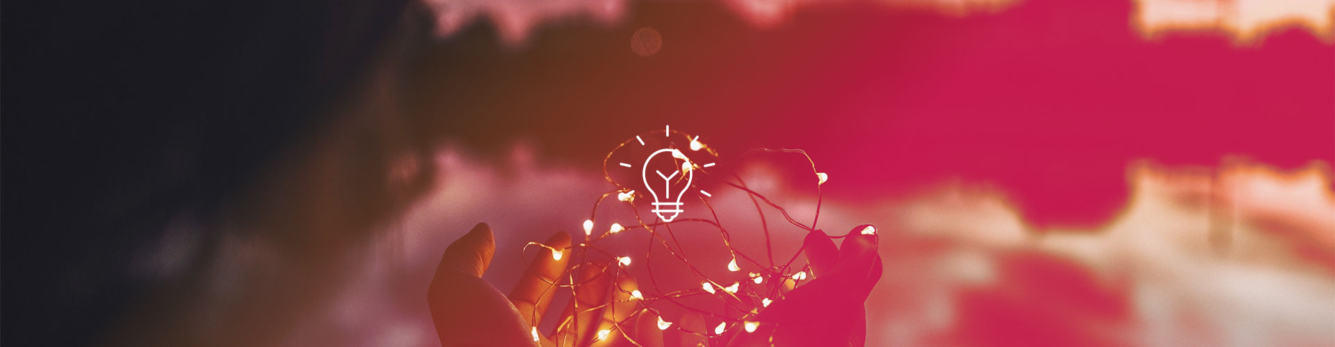 Hände halten ein eingeschaltete Lichterkette, in der Mitte ein Icon einer Glübirne