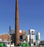 Anlage von außen mit dem Schornstein im Mittelpunkt